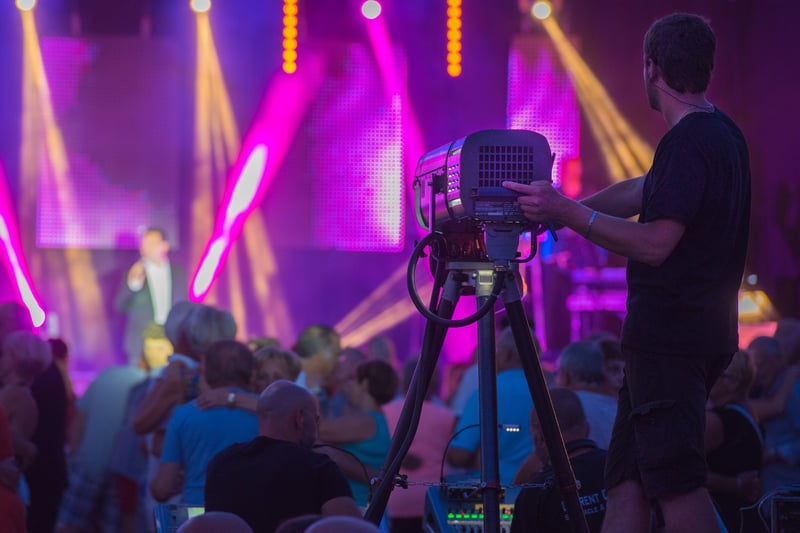 cameraman filming stage with a crowd of people