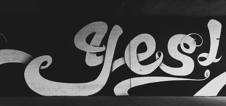 the word yes graffiti painted on a wall