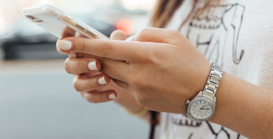 woman's hands holding smartphone