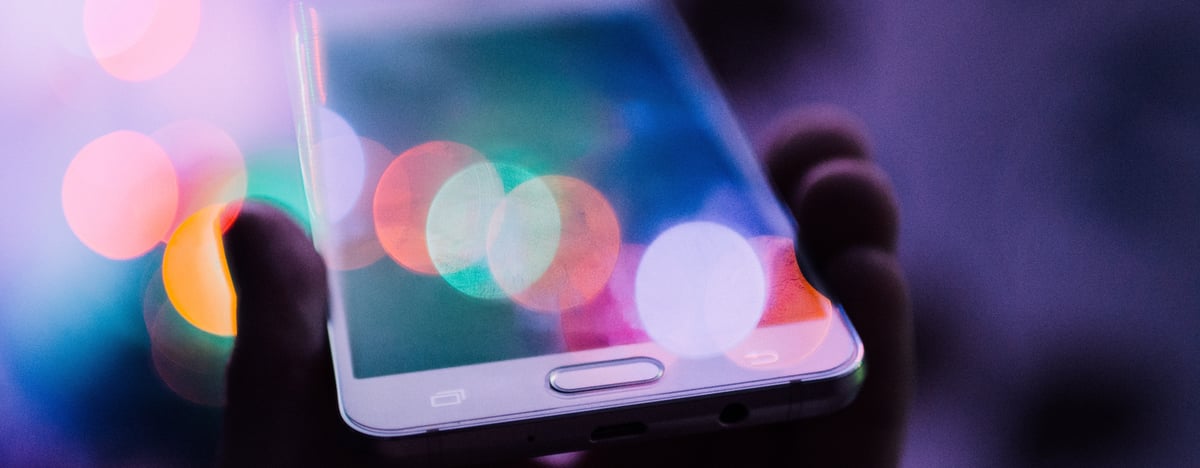 smartphone in hand with colourful lights