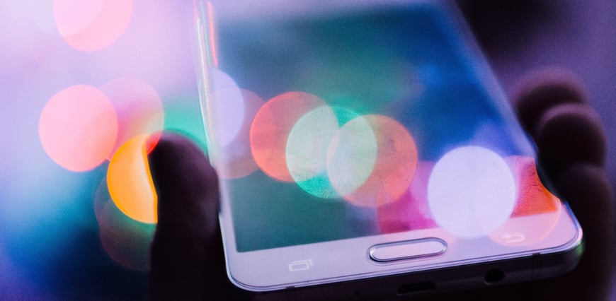 Smartphone in hand with multi-coloured lights